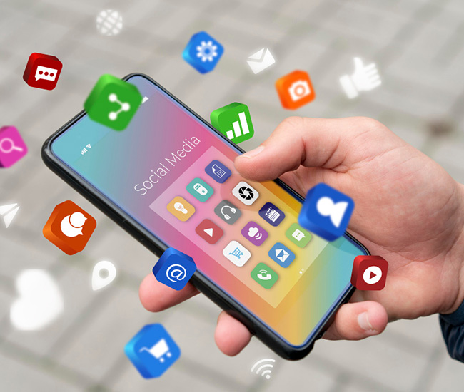 A person uses a laptop displaying a website builder interface, with a smartphone and tablet showing the same website design; green plants are visible at the top corners of the workspace.